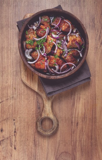 Fried meat, pork kebab, ketsi in a clay pan, with red onions and herbs, homemade, no people