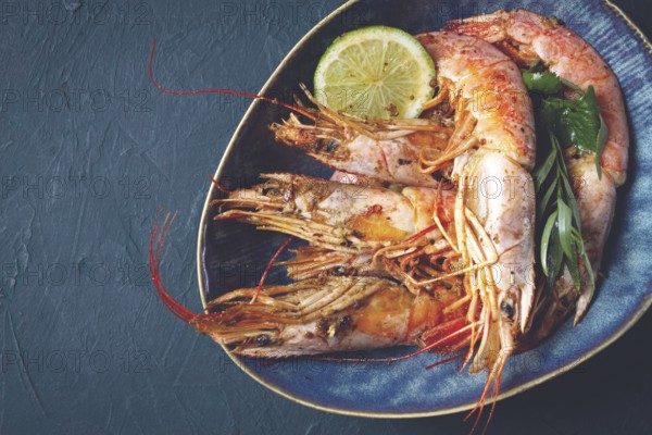 Langoustines, Australian, freshly frozen on ice, top view, lime and greens