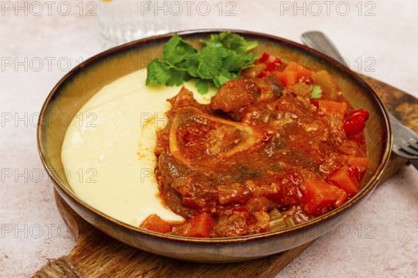 Ossobuco, stewed meat knuckle on the bone, with mashed potatoes, and oats and spices, homemade, no people