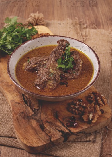 Fesenjan, an Iranian dish, stewed chicken, in a nut-pomegranate sauce, in a bowl, homemade, no people