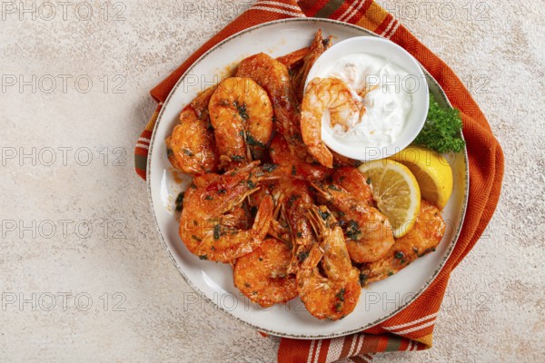 Fried white-footed shrimp, tiger prawns vannamey, on a plate, with lemon and herbs, no people