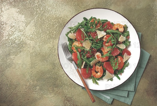 Fresh shrimp salad with arugula, grapefruit, and parmesan served in a bowl