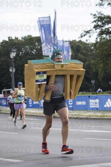 A runner with the Brandenburg Gate as a foam dummy on the Great Star at the 51st BMW Berlin Marathon 2025 on 21 September 2025