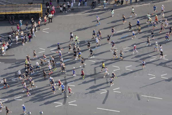 Runners with long shadows on the big star seen from the Victory Column at the 51st BMW Berlin Marathon 2025 on 21 September 2025