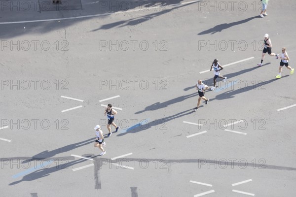 Runners with long shadows on the big star seen from the Victory Column at the 51st BMW Berlin Marathon 2025 on 21 September 2025