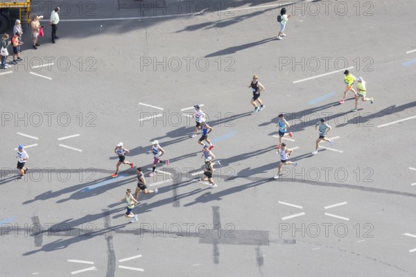 Runners with long shadows on the big star seen from the Victory Column at the 51st BMW Berlin Marathon 2025 on 21 September 2025