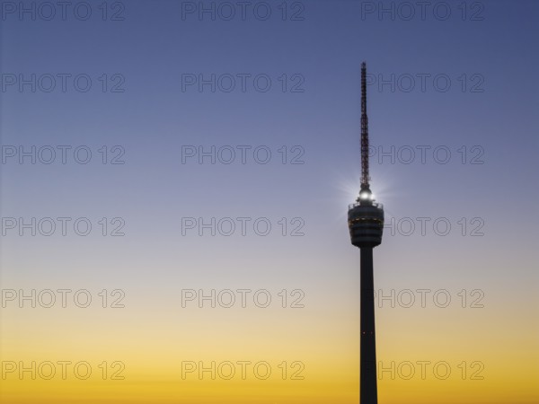 Illuminated television tower in front of a harmonious yellow-blue morning sky, Stuttgart, Baden-Württemberg, Germany