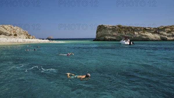 People swimming in the open sea, a boat approaches the rocks, White Cliffs, White Beach, Makri Aspronisi Island, Natura 2000 area, boat trip, Aspronisi, Lipsi, Dodecanese, Greek Islands, Greece