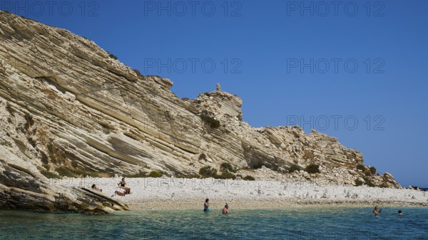 Rocky coast with people walking along the beach and swimming in the sea, White Cliffs, White Beach, Makri Aspronisi Island, Natura 2000 area, Boat trip, Aspronisi, Lipsi, Dodecanese, Greek Islands, Greece