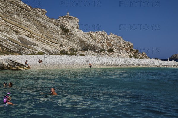 People swimming in calm turquoise waters off a rocky coast, White Cliffs, White Beach, Makri Aspronisi Island, Natura 2000 area, boat trip, Aspronisi, Lipsi, Dodecanese, Greek Islands, Greece