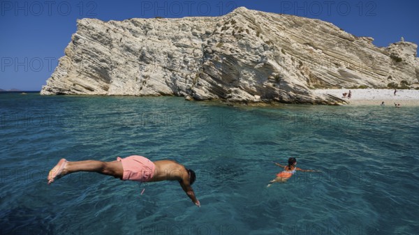 People swimming in clear blue water in front of impressive rocky cliffs, White Cliffs, White Beach, Makri Aspronisi Island, Natura 2000 area, boat trip, Aspronisi, Lipsi, Dodecanese, Greek Islands, Greece
