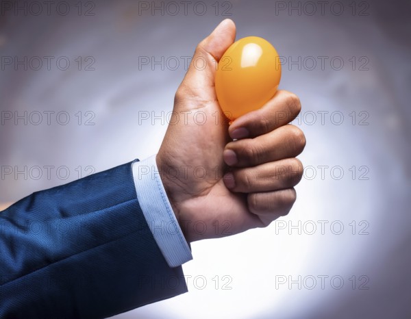A suited hand squeezing an orange stress ball, symbolizing stress relief, productivity, and determination. Captures the essence of focused relaxation and corporate empowerment in a professional environment, AI generated