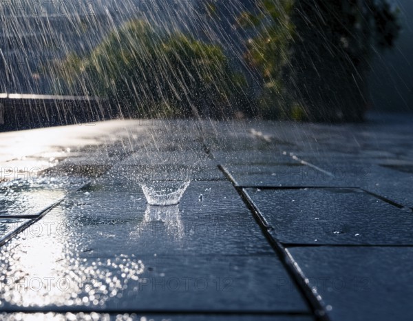 Close-up image showing rainfall splashing on wet ground during daylight in the background, AI generated