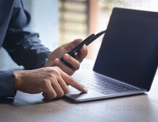 A man in a professional office environment multitasking with a smartphone and laptop, conveying productivity, technology integration, and modern working practices, AI generated