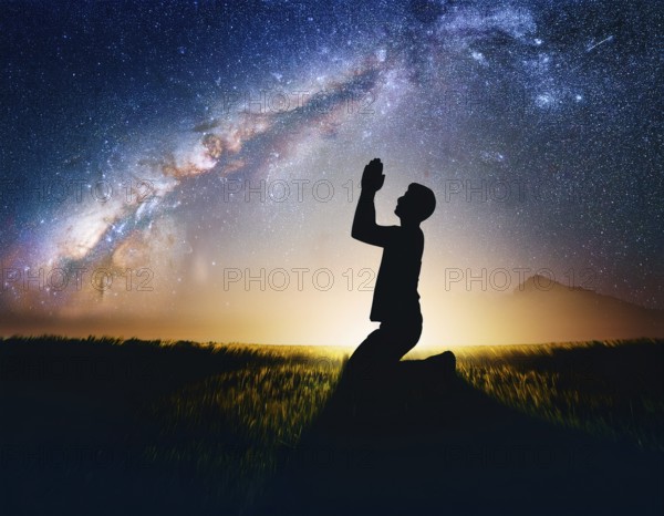 A man kneels in peaceful reflection under the vibrant Milky Way galaxy at sunset in an open natural setting, making prays, AI generated