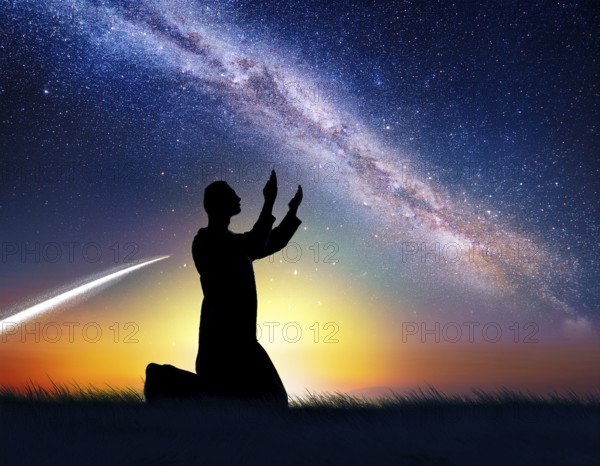 A man kneels in peaceful reflection under the vibrant Milky Way galaxy at sunset in an open natural setting, making prays, AI generated