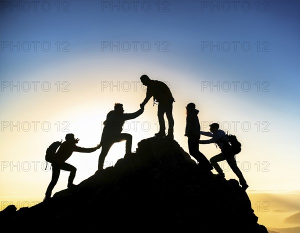 A dynamic depiction of teamwork and determination, climbers ascend a rugged mountain peak during sunset, silhouetted against a vibrant, colorful sky, AI generated