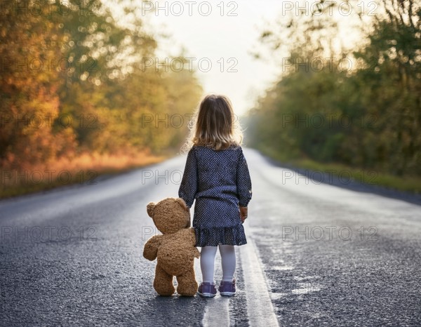 A young child stands alone holding a teddy bear in an urban outdoor setting, symbolizing innocence and isolation, AI generated