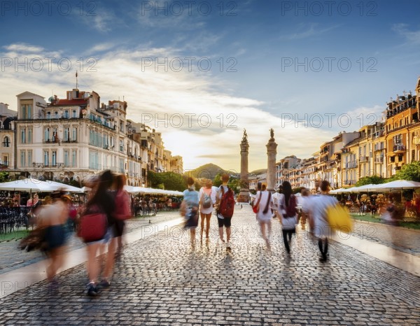 Historical city square with iconic architecture, cobblestone streets, and vibrant motion of pedestrians enjoying the surroundings, AI generated