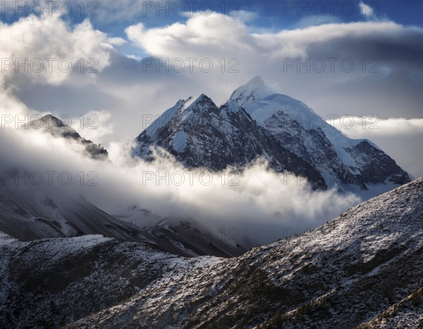 A stunning view of a snowy mountain peak rising above the clouds, with a blue sky background. Capturing a tranquil moment in nature's beauty, evoking feelings of serenity and wonder, AI generated