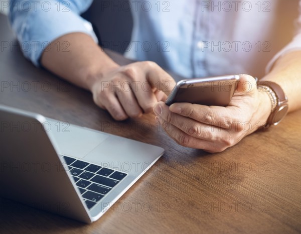 A man in a professional office environment multitasking with a smartphone and laptop, conveying productivity, technology integration, and modern working practices, AI generated