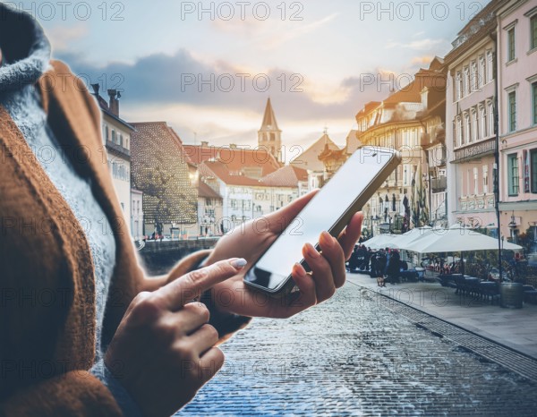 A person holding a smartphone at an outdoor cafe amidst a vibrant and lively urban setting. The image captures a relaxed moment with modern technology interaction and a scenic cityscape, AI generated