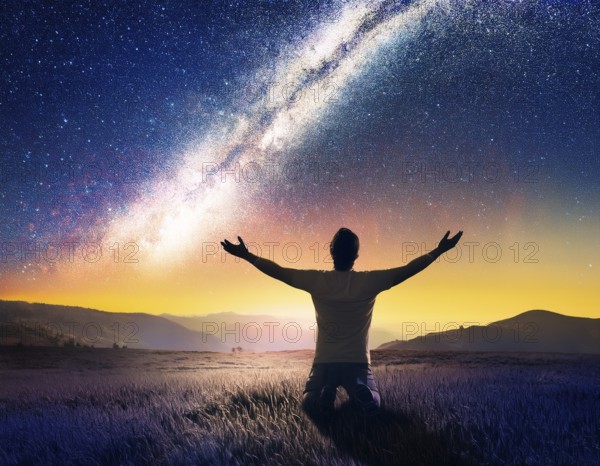 A man kneels in peaceful reflection under the vibrant Milky Way galaxy at sunset in an open natural setting, making prays, AI generated
