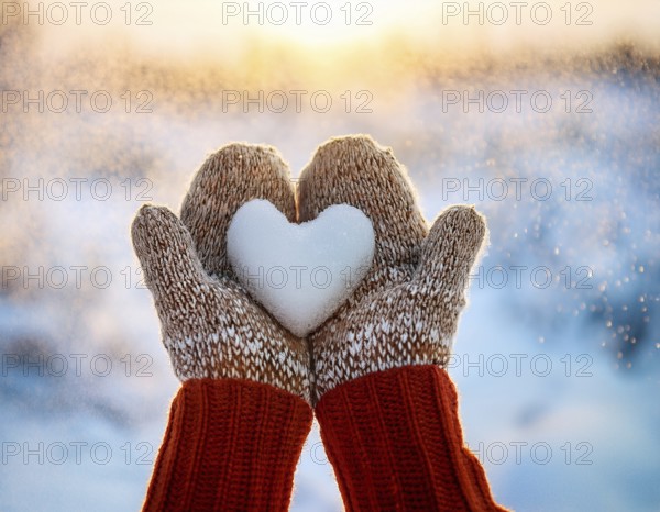 Serene winter scene showcasing hands in gloves holding a snow heart symbolizing love and warmth, AI generated