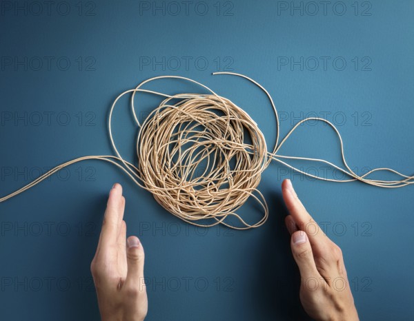 A close-up of a professional ipresenting a piece of intricate, tangled wire, symbolizing complexity, solution-finding, and creative problem-solving in a business or conceptual context, AI generated