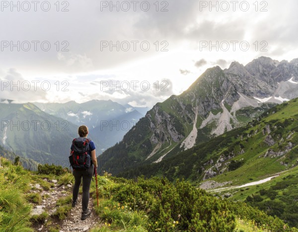Traveler with backpack overlooking mountain valley at sunrise, symbolizing adventure, exploration, freedom, and connection with nature, AI generated