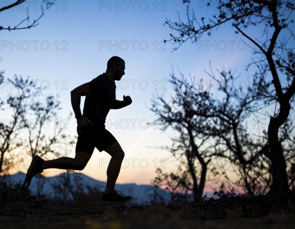 A cinematic silhouette of an athletic man running, representing fitness, endurance, wellness, and healthy active living, AI generated