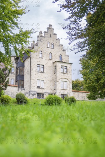 A Gothic castle rises imposingly above a green lawn under a clear sky, Lichtenstein Castle, Lichtenstein, Swabian Alb, Germany