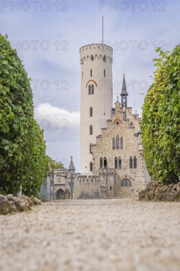 Majestic castle with towers and manicured hedges, captured from a view along a cobbled path, Lichtenstein Castle, Lichtenstein, Swabian Alb, Germany