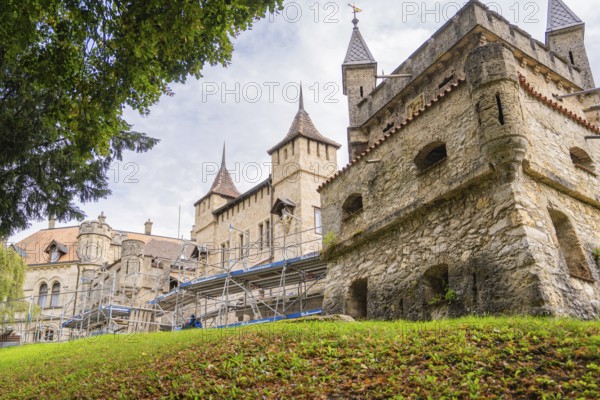 Old castle with towers and scaffolding for renovation in green surroundings, Lichtenstein Castle, Lichtenstein, Swabian Alb, Germany