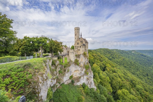 Impressive castle stands on a lush cliff, surrounded by mountains and sky, Lichtenstein Castle, Lichtenstein, Swabian Alb, Germany