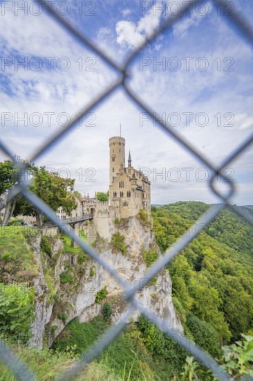 Castle on a hill seen through a lattice, surrounded by forest, Lichtenstein Castle, Lichtenstein, Swabian Alb, Germany