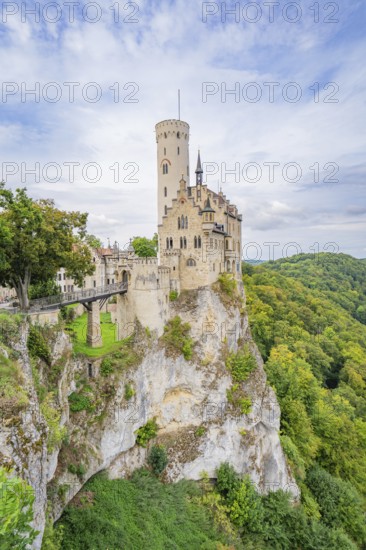 Castle stands impressively on a green cliff under a blue sky, Lichtenstein Castle, Lichtenstein, Swabian Alb, Germany