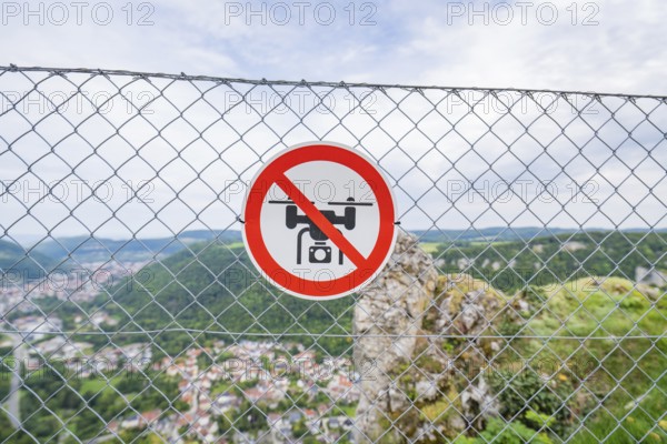Lattice fence with drone prohibition sign in front of a wide panoramic view over the landscape, Lichtenstein Castle, Lichtenstein, Swabian Alb, Germany