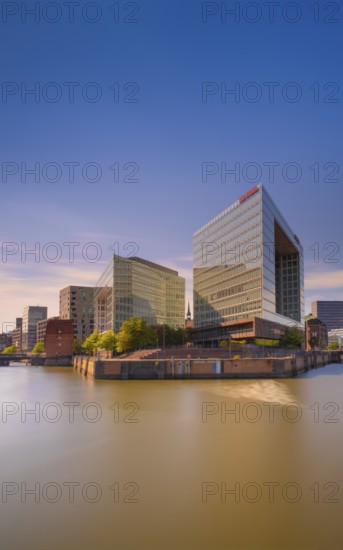 Photograph of light reflections on the water surface from a long exposure and the mirror building at Oberehafen and Ericusgraben from the Oberhafenbrücke, Hamburg, Germany