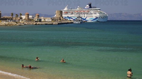 Large cruise ship in the harbour near a beach with turquoise water and bathers, Sachtouri Beach, Rhodes Old Town, Rhodes Town, Rhodes, Dodecanese, Greek Islands, Greece