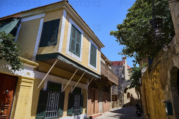 Colourful house facades with shutters in a historic alley, Turkish Quarter, Rhodes Old Town, Rhodes Town, Rhodes, Dodecanese, Greek Islands, Greece