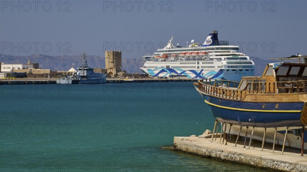 Coastal view with traditional boat and cruise ship in the harbour in sunny weather, Rhodes Old Town, Rhodes Town, Rhodes, Dodecanese, Greek Islands, Greece