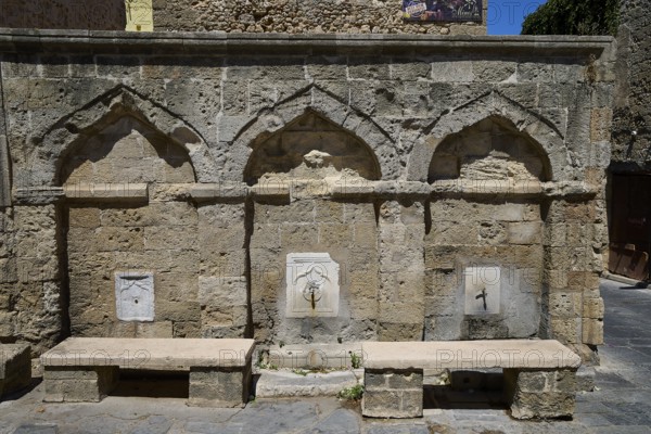 Fountain, washing facilities, near Borsani Mosque, Omirou Street, Ancient sandstone structure with three arches and a decorative water fountain, flanked by stone benches, Rhodes Old Town, Rhodes Town, Rhodes, Dodecanese, Greek Islands, Greece