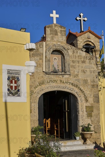 Church of Agios PanteleimoChurch entrance with icon painting and crosses, yellow wall in the foreground, Rhodes Old Town, Rhodes Town, Rhodes, Dodecanese, Greek Islands, Greece