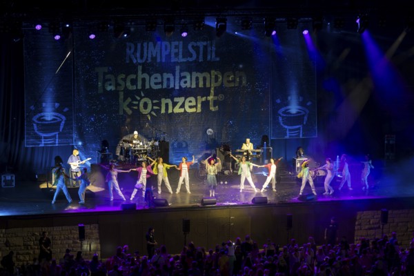 The band Rumpelstil consisting of Jörn Brumme (boss / voc, fl, git), Peter Schenderlein (director / voc, piano, keyb), Blanche Elliz (boss, vic, acc, perc), Max von Thien (leader / voc, drum, perc) with dancers at the 25th Berliner Taschenlampenkonzert at the Berliner Waldbühne on 20.09.2025
