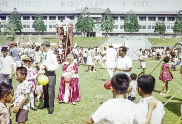 Garden fete community event in the grounds of HMS Terror naval base, Sembawang, Singapore, South East Asia, 1963 - some people in fancy dress clothing