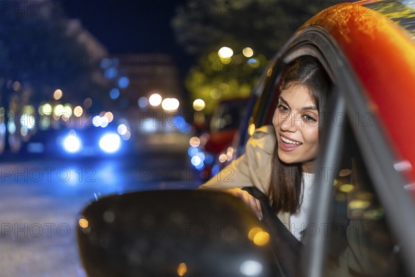 Woman looking out car window enjoying a vibrant city night with blurred lights creating bokeh, representing travel, urban exploration, and joyful evening rides