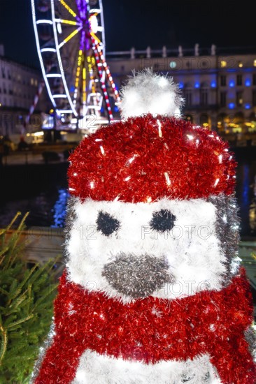 Festive penguin decoration adds a touch of magic to the christmas market in bayonne, france, with a ferris wheel twinkling in the background