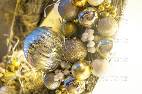 Close up of a christmas wreath with gold and silver shiny ornaments and white berries, adding a festive touch to the holiday season in bayonne, france