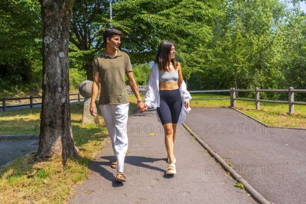 Happy couple enjoying a relaxing walk together in nature, holding hands and talking on a sunny summer day